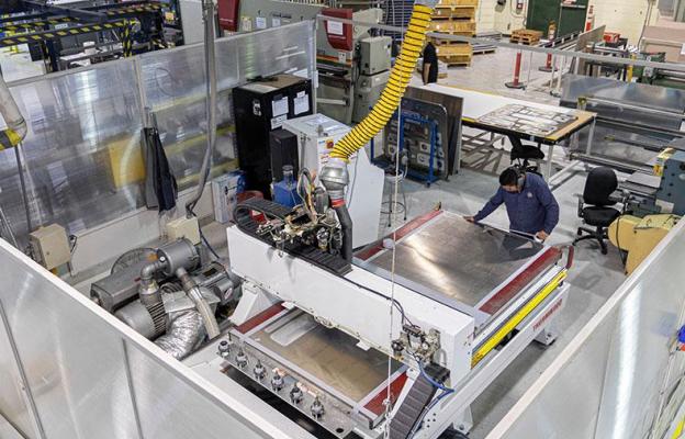 Overhead shot of a man placing sheet metal panels on a machine'