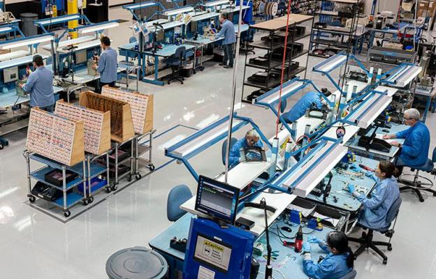 Overhead view of factory and people sitting or standing at workstations