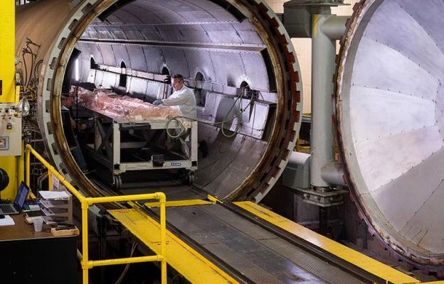 Man working on parts inside an autoclave