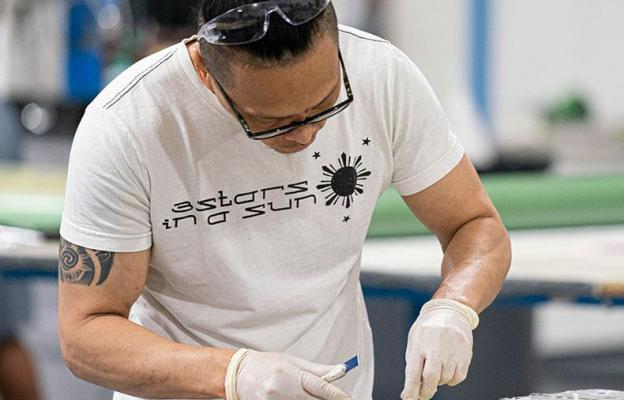 Man working with large metal part on table