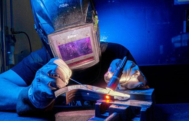 Person in helmet welding a part