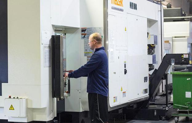 Man operating large CNC machine