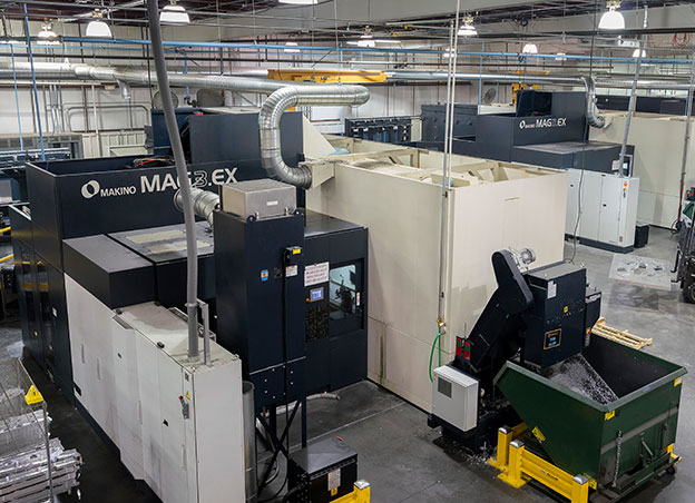 Man standing next to large multi-axis machining tool