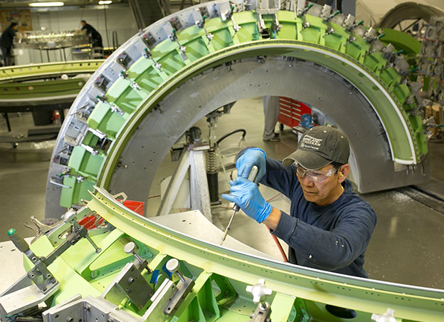Man riveting a large bulkhead assembly