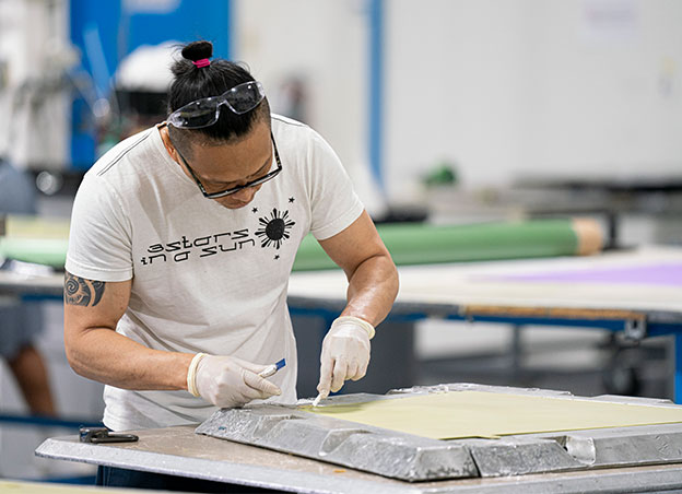 Man working on metal part at table