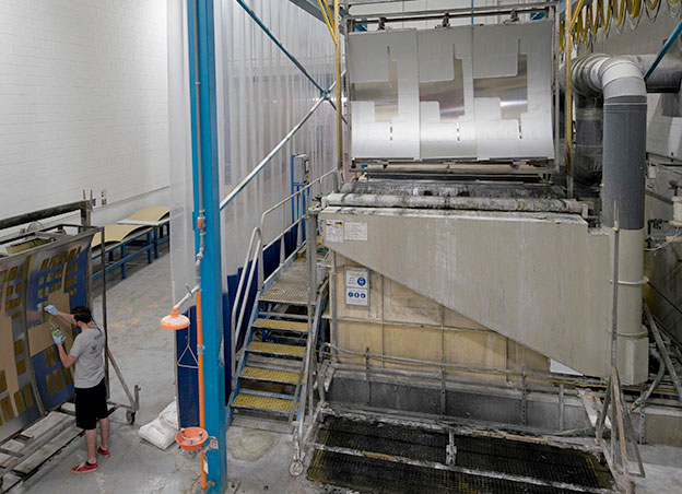 Man operating chemical milling machine