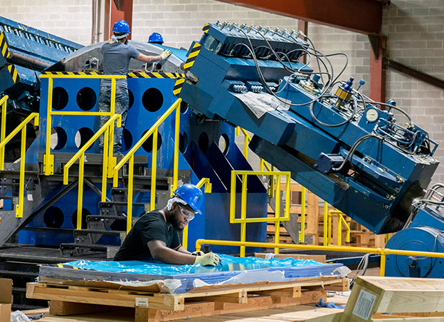 Man working at table in front of L-1500 machine