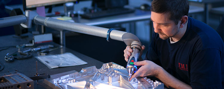 Hands using a tool on a metal part