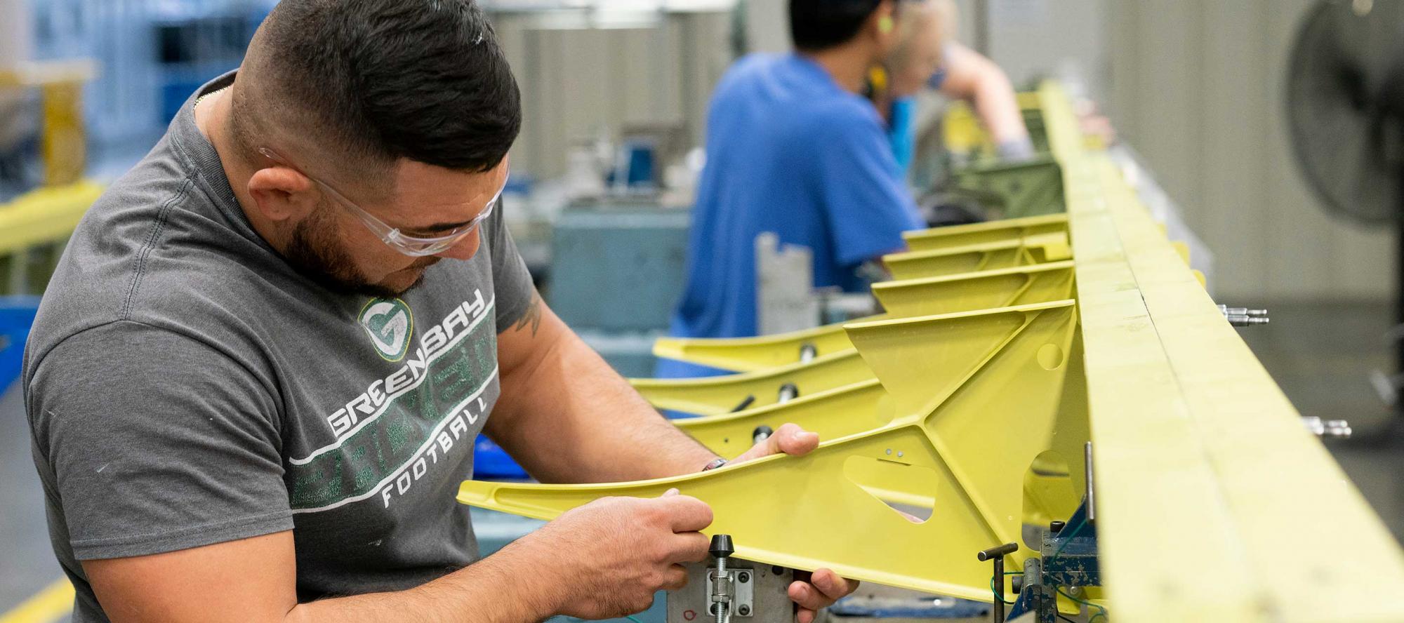 Man working on large wing spar